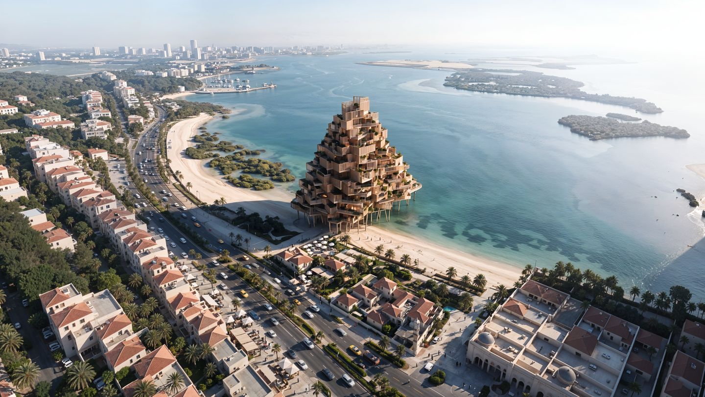 Aerial view of a terraced, stepped tower rising from the shallows beside a beach, with the city beyond.