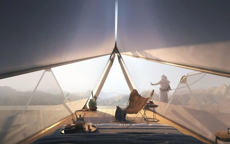 The Floating Retreat · Sharjah mountains — inside a suspended room, a guest looking out over the mountains